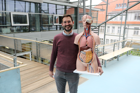 Ein Professor mit dem Korpus im Hochschulgebäude