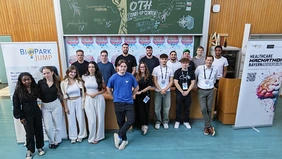 Gruppenbild mit Studierenden und Professor in einem Hörsaal
