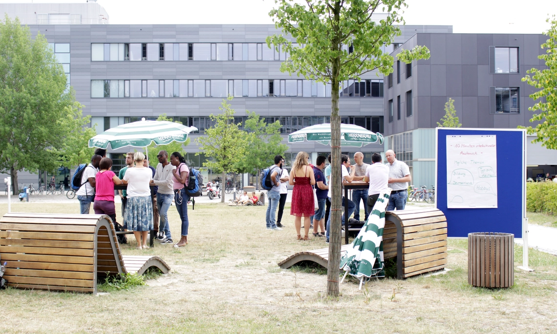 Menschen auf der Campus Wiese im Gespräch