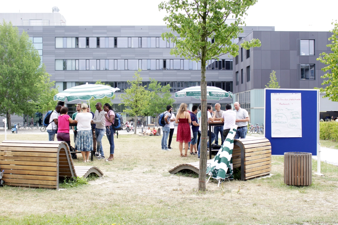 Speed Talk auf der Campus Wiese: Die Teilnehmer im Austausch mit deutschen Muttersprachlern. Quelle: THI Menschen auf der Campus Wiese im Gespräch