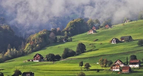 Traditionelle Häuser an einem Hang in den Alpen