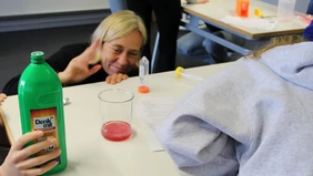 Die Professorin und die Schülerinnen beobachten, wie die DNA sichtbar wird.