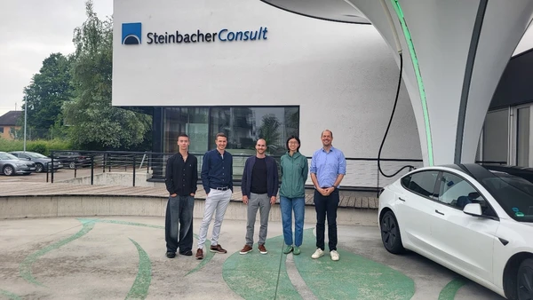 Vor dem Firmengebäude von Steinbacher-Consult direkt neben dem charakteristischen „Ladepilz“ (v.l.n.r. Maxime Lucas, Benjamin Dietz und Steffen Lauter von Steinbacher-Consult; Jiahe Chu und Prof. Matthias Huber von THI, InES)