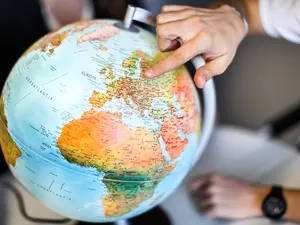 a staff member of the IO points on a globe