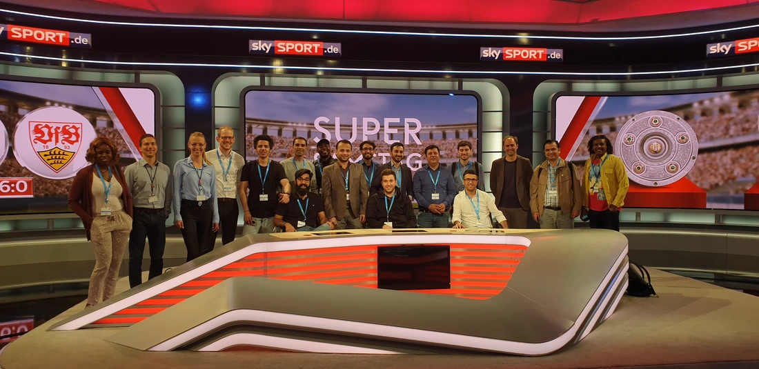 Blick hinter die Kulissen: Die Teilnehmer zu Gast bei Sky. Quelle: Sky Deutschland Fernsehen GmbH & Co. KG Menschen hinter Moderationspult in Studio