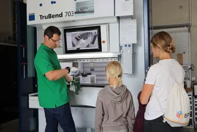 Einblicke ins Labor gab es bei Professor Klaus-Uwe Moll (Foto: THI). Mann zeigt Kind und Frau Ergebnis aus der Werkzeugmaschine