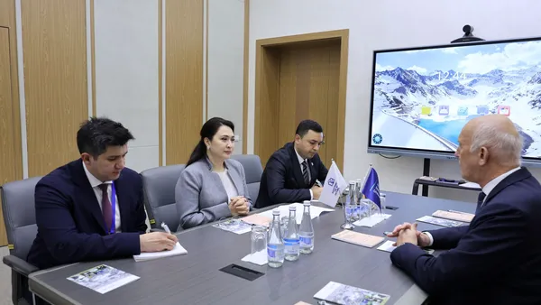 Präsident der Hoschule am Tisch mit drei Personen der New Uzbekistan University