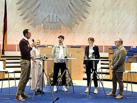 Fünf Personen am Stehtischen während einer Podiumsdiskussion