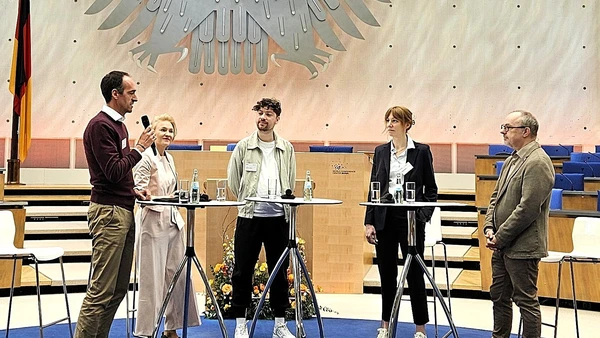 Fünf Personen am Stehtischen während einer Podiumsdiskussion
