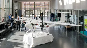Eine Erfolgsgeschichte: Zum 11. Mal traf sich die Urban Air Mobility Initiative Ingolstadt (Foto: UAM). Einblick in das Urban Air Mobility Treffen in der Aula der THI, zusehen sind Ausstellungsmodelle sowie Gastgeber und Teilnehmer