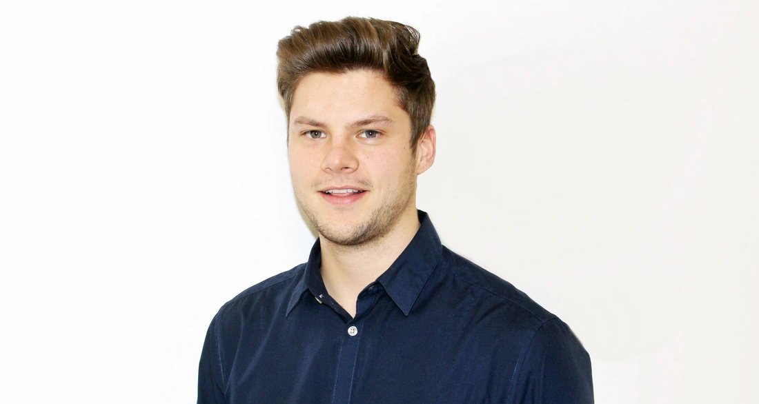 Philipp Knöferl, ehrenamtlicher Mentor am Integrationscampus. Quelle: THI Porträtfoto Mann vor Wand