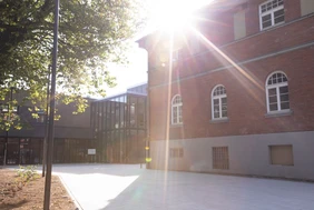 Symboldbild vom Campus mit strahlender Sonne am Himmel