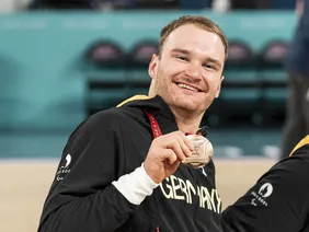 This is what winners look like: Lukas Gloßner with his medal (Photo: Ana Sasse). Portrait von Student Lukas Glossner bei einem sportlichen Wettbewerb, wie er seine Medaille zeigt