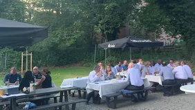Nach dem Vortrag kamen die rund 30 Gäste miteinander ins Gespräch (Foto: THI). Zusammensitzen der Gäste beim Sommerfest in Neuburg Auf Bierbänken unter Sonnenschirmen