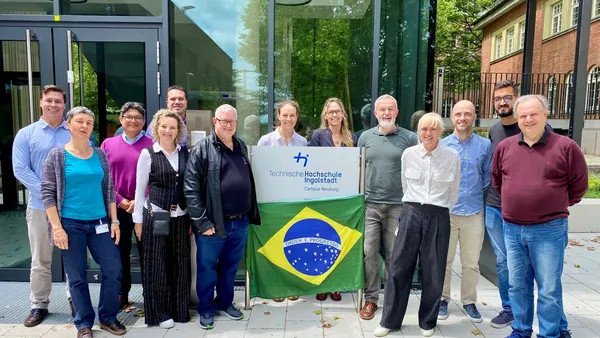 Gruppenbild der Gastfamilien am Campus in Neuburg mit einer Brasilien-Flagge