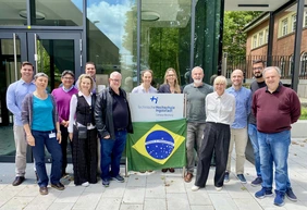 Gruppenbild der Gastfamilien am Campus in Neuburg mit einer Brasilien-Flagge