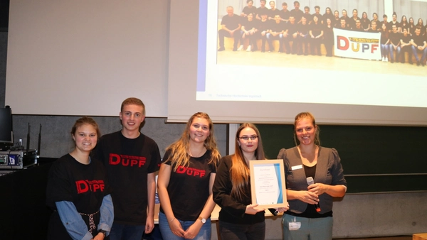 Gruppe von Menschen mit Urkunde bei Preisverleihung